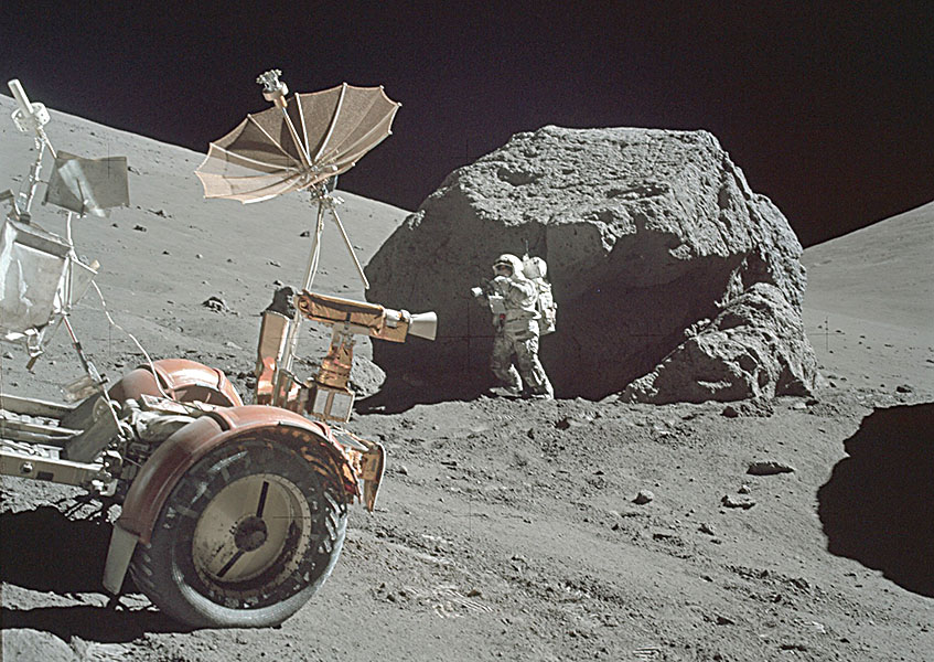 Apollo 17 astronaut, lunar rover, and boulder on the Moon