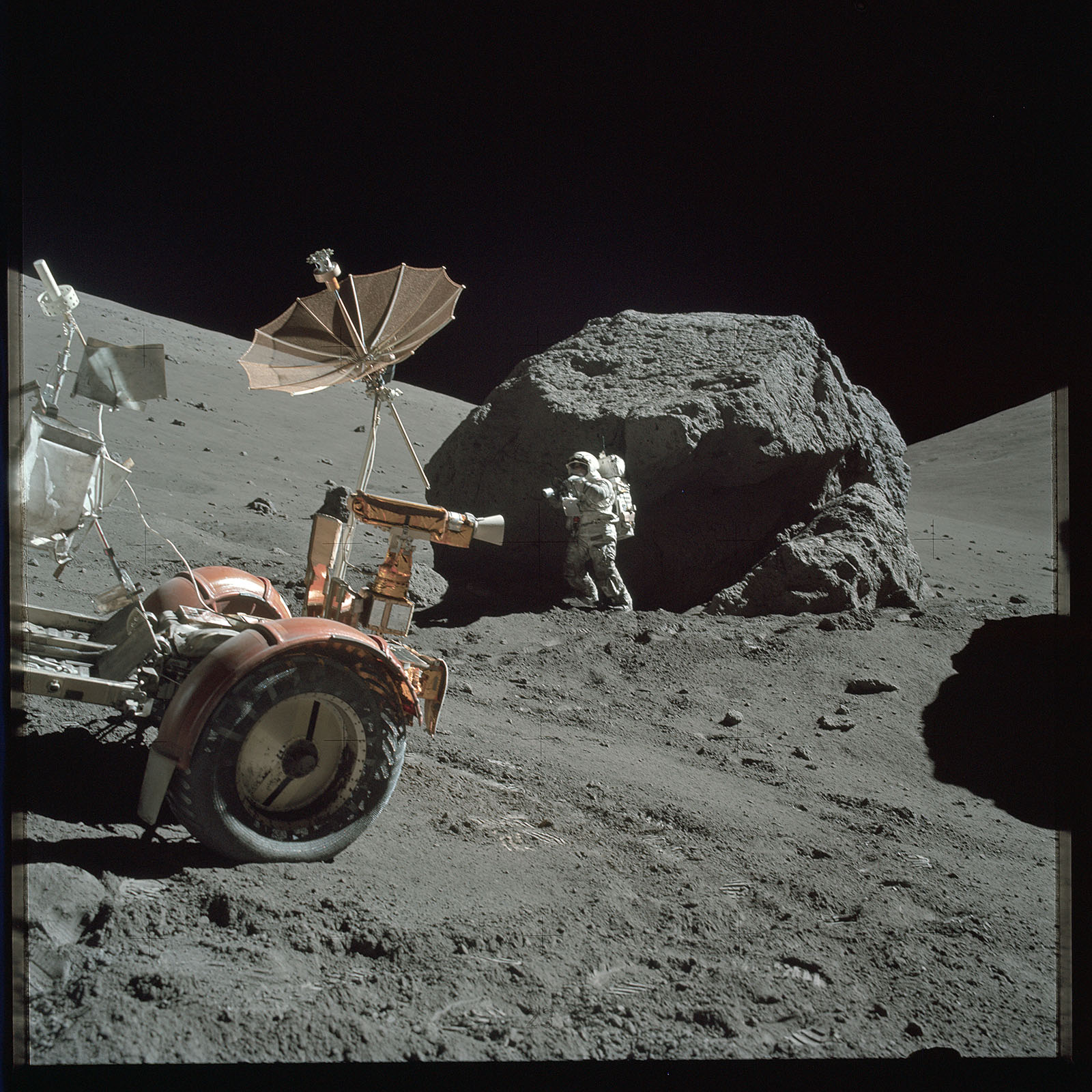 Apollo 17 astronaut exploring the boulders of Station 6 beside the Lunar Roving Vehicle; NASA image AS17-146-22294